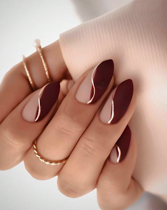 Maroon nail polish with gold stripes